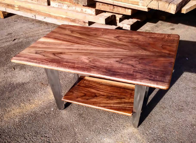Custom wooden coffee table with richly patterned grain, a lower shelf and metal legs